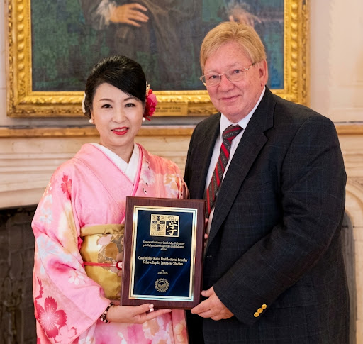 着物姿とスーツ姿の2人が記念盾を手に並ぶ様子
